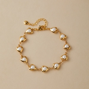 Detail of 18K gold plated heart bracelet with white shell inlay and lobster clasp