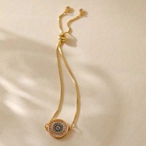 Detailed view of evil eye gold charm bracelet with adjustable box chain closure