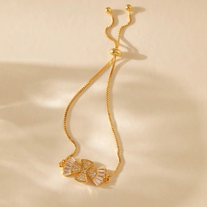 Detailed macro of gold-plated bracelet with zircon fan charms and adjustable box chain