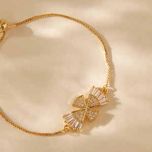 Detail view of gold-plated box chain bracelet with cubic zirconia charms and sliding clasp