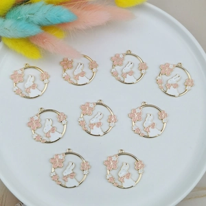 Flat lay of bunny and cherry blossom enamel pendants for DIY jewelry making