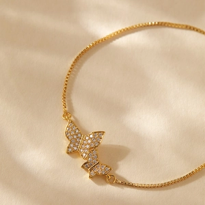 Detail of adjustable gold-plated bracelet featuring zircon-encrusted butterfly charms