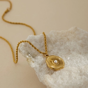 Dettaglio della collana malocchio dorata con catena a corda e perla incastonata
