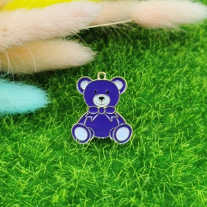 Détail macro d'une breloque ours en émail violet avec bordure dorée pour bijoux DIY