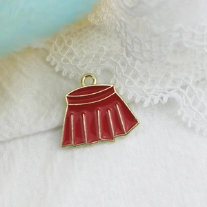 Detail macro-opname van een rode emaille rok bedel met gouden randen voor DIY sieraden