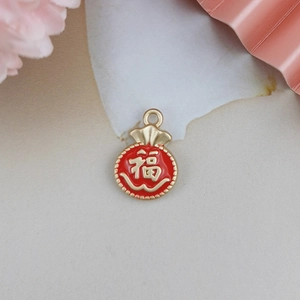 Detail of red enamel lucky bag pendant with gold Chinese Fu character for DIY jewelry making