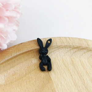 Macro view of matte black bunny charm pendant with hanging hole for DIY jewelry making