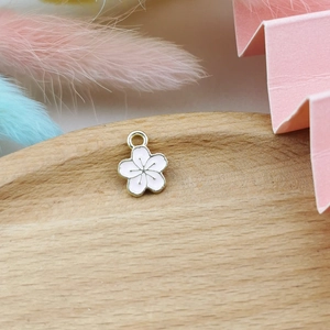 Detailed view of a pink cherry blossom flower pendant with gold trim for DIY jewelry