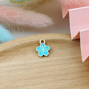 Detail of light blue five-petal flower charm with gold trim for DIY jewelry making