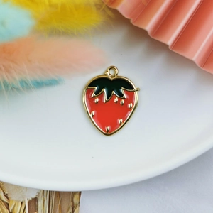 Macro détaillée d'un pendentif fraise en émail rouge pour la création de bijoux DIY
