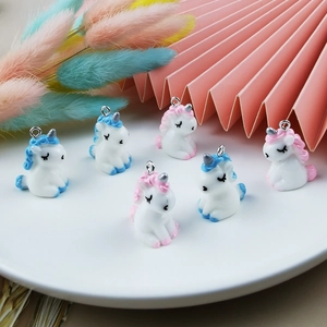 Set of six resin unicorn charms for DIY jewelry and keychains on a decorative white tray