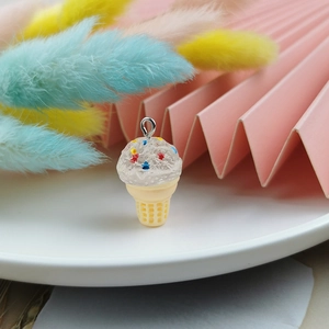 Macro detail of resin ice cream charm with colorful sprinkles and golden ring attachment