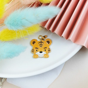 Détail du pendentif petit tigre en émail orangé pour la création de bijoux DIY créatifs