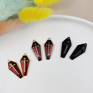 Macro view of gothic coffin cross charms in red and black enamel for DIY jewelry