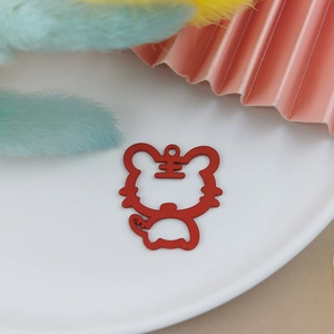 Macro shot of a red hollow tiger charm with Chinese character Wang for jewelry DIY