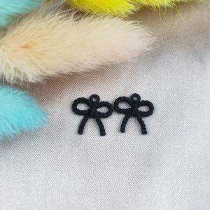 Vista macro de colgantes de lazo negro mate con textura trenzada para pendientes DIY