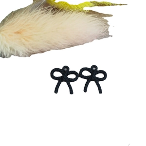 Elegantes pendientes de lazo negro con textura trenzada y estilo otoñal minimalista