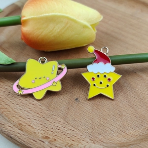 Detailed view of DIY star and Christmas hat charms on a wooden tray with flowers