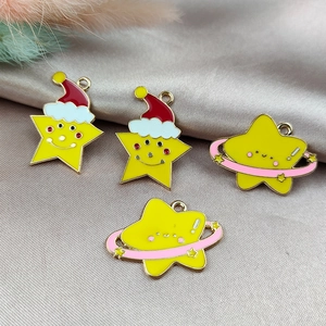 DIY Christmas star charms with red hats and planets on silver satin background