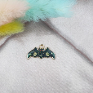 Détail d'un pendentif chauve-souris d'Halloween avec paillettes noires sur satin argenté