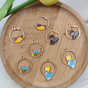 Detail of DIY alloy charms set with squirrel acorn and heel designs on a wooden tray