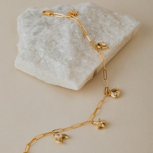 Détail du bracelet de cheville doré avec breloques coquillage et étoile de mer