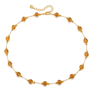 Detail of gold chain with amber glass beads, lobster clasp and extension chain