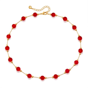 Detail of red faceted glass beads on a gold-plated necklace with lobster clasp