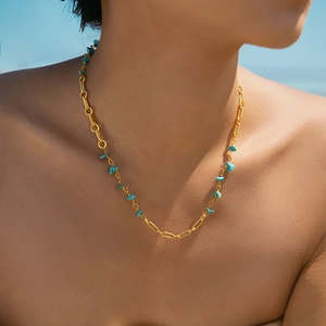 18K vergulde ketting met onregelmatige turquoise stenen gedragen door een model