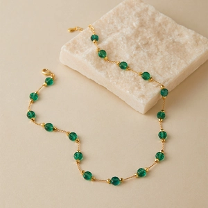 Detail of 18K gold plated chain with emerald green multifaceted crystal beads