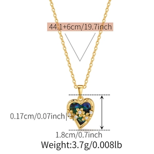 Detail view of heart pendant necklace with blue shell inlay and three gold flower accents