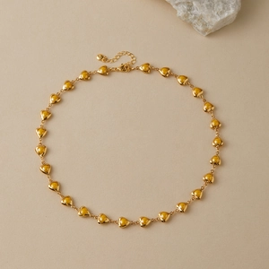 Detail of 18K gold-plated heart necklace with yellow pearlescent inlay and lobster clasp