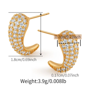 Primer plano de aretes dorados en forma de J con circonitas y medidas de dimensiones