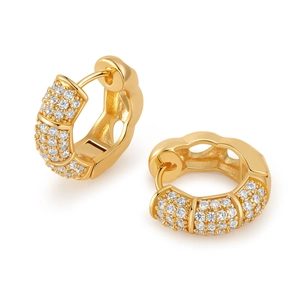 Vista macro de pendientes bañados en oro con micro-pavé de circonitas blancas brillantes