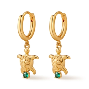 Detailed view of golden turtle hoop earrings featuring a vibrant green round gemstone
