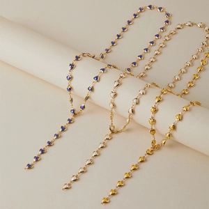 Détail de colliers plaqués or avec des cœurs en émail bleu, blanc et jaune