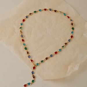 Vue détaillée d'un collier en Y doré avec des pierres précieuses rectangulaires