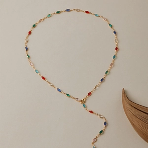 Détail de gemmes marquise colorées sur un collier lariat doré de style bohème chic