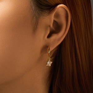 Nahaufnahme der goldfarbenen Stern-Creole mit glitzernden Kristallen am Modell