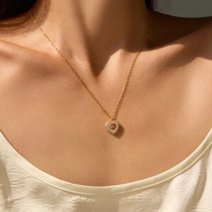 Close-up of heart pendant necklace with dancing stone detail on model's neck