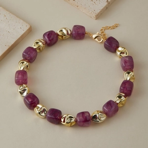 Dettaglio della collana con perle di marmo viola e perline metalliche dorate lucide