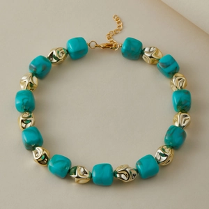 Dettaglio della collana retrò con perle di marmo blu e inserti metallici dorati lucidi