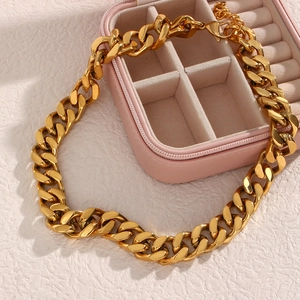 Detail of gold Cuban link chain necklace with lobster clasp and adjustable tail chain
