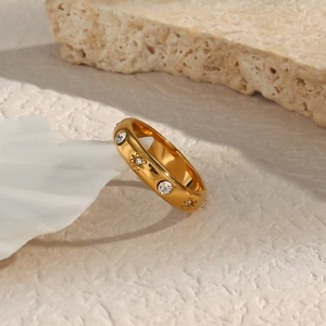 Dettaglio macro di anello placcato oro 18K con zirconi chiari e incisioni a stella