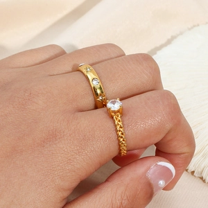 Elegante set di anelli in acciaio placcato oro 18K con pietre di zircone sulla mano