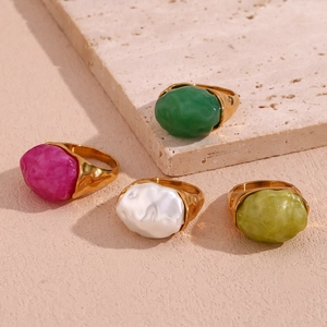 Detailed macro view of four 18K gold-plated rings with colorful natural mineral stones