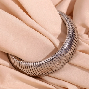 Detailed close-up of 20mm wide silver snake chain bracelet on smooth beige silk