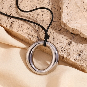 Pendentif anneau en acier inoxydable poli présenté sur un support en pierre