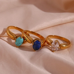 Drei Goldringe mit Türkis, Lapislazuli und Zirkon auf Seide in der Detailansicht
