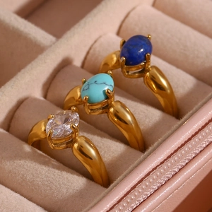 Makro-Detail von drei 18K vergoldeten Ringen mit blauen Steinen in rosa Samtbox